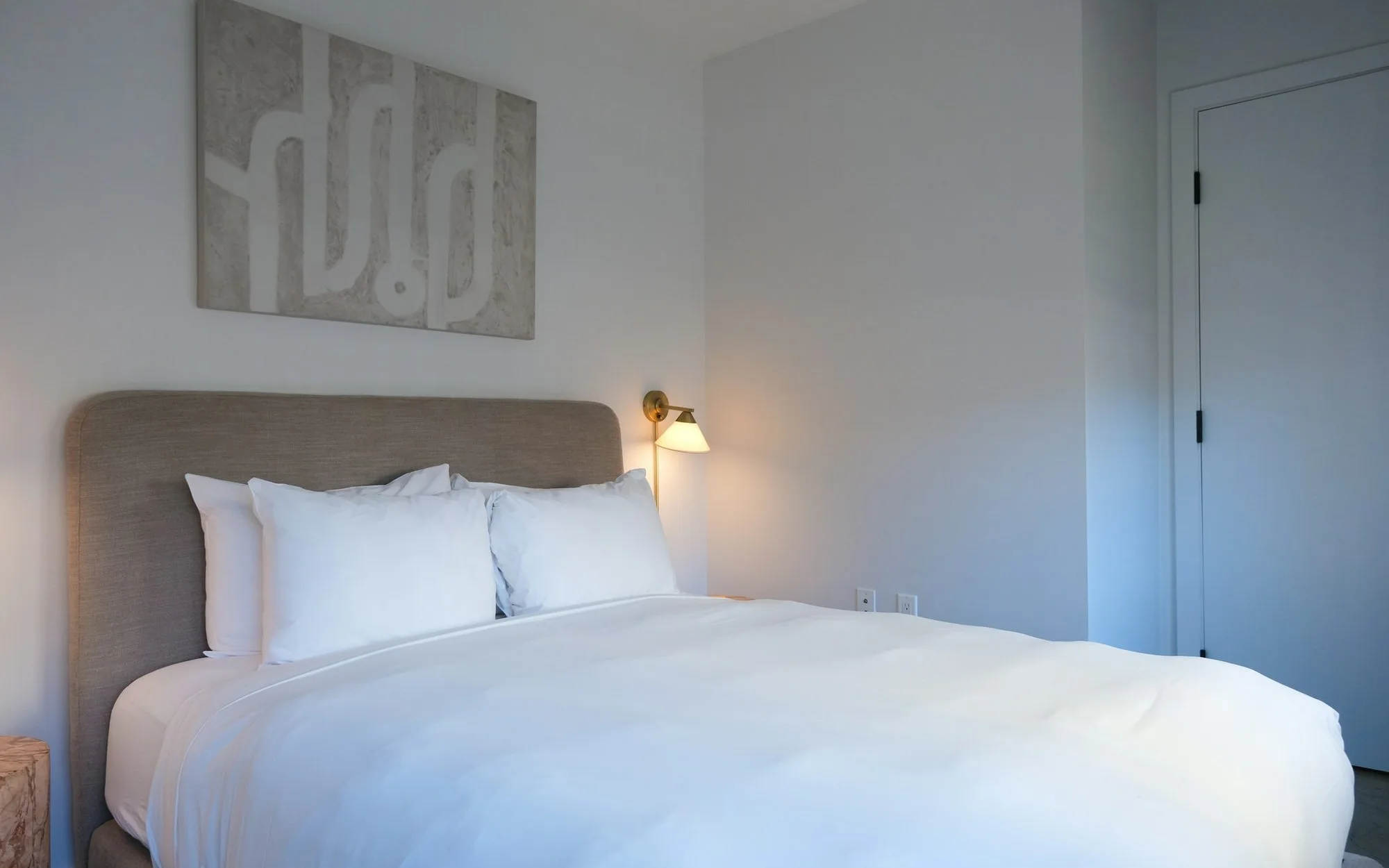 Chambre La Longère : lit bien fait, œuvre au mur