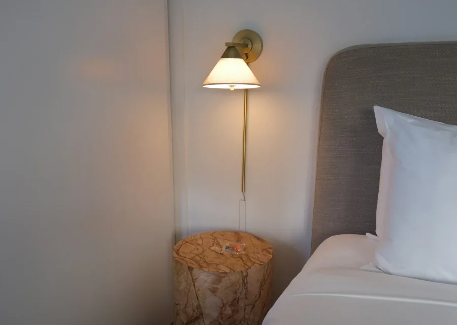 Chambre Le Grenier : applique en laiton et tabouret de bois