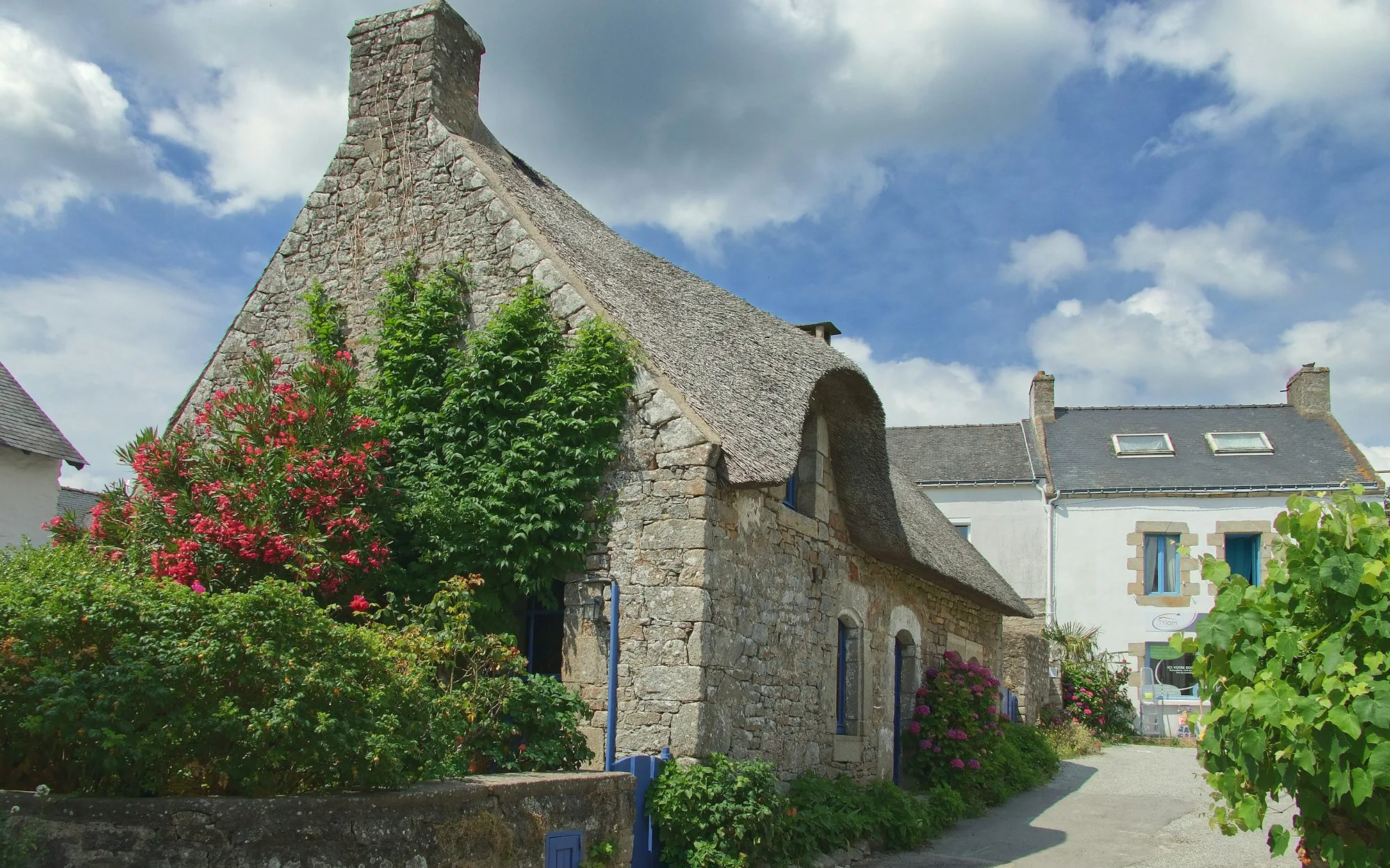 La longère en pierre et ses rosiers, toit d'ardoise