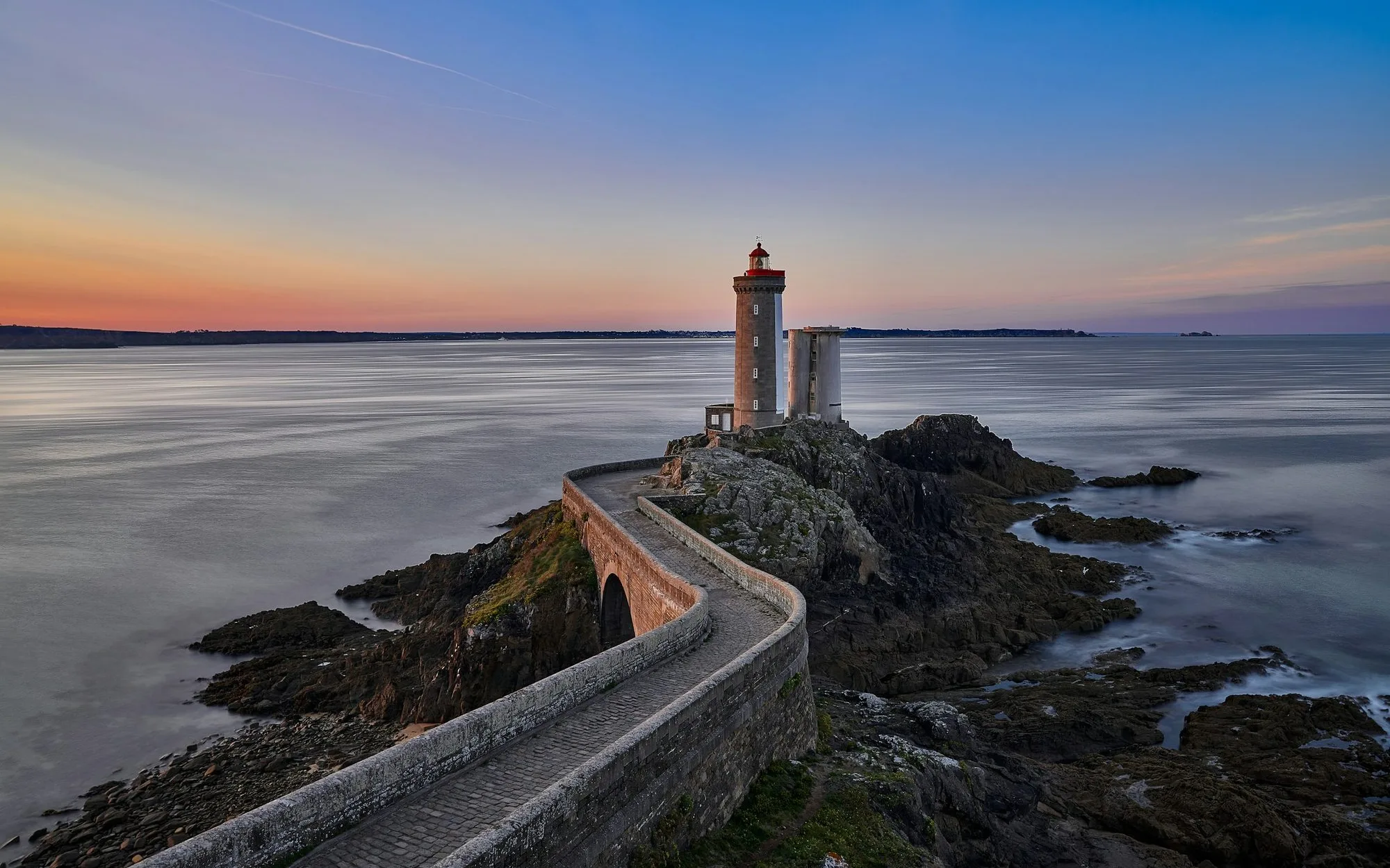 Le phare du Petit Minou au crépuscule, mer d'huile et ciel orangé