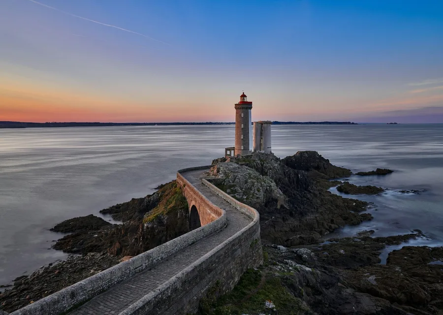 Le phare du Petit Minou au crépuscule, mer d'huile et ciel orangé